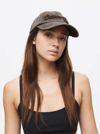 Model wearing Washed Hat in Charcoal, showing raised topstitching detail and curved brim.