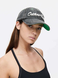 Woman wearing a Washed Hat with Outdoor Voices logo, with the stylish topstitching.