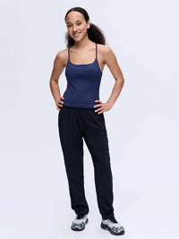 Model smiling in Zephyr 26" Pant in Black, featuring a custom-fit drawstring waist and zippered pockets.