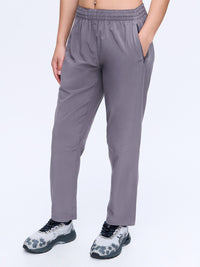 Model standing in Zephyr 26" Pant in Grey, designed with a custom-fit drawstring waist and zippered pockets.