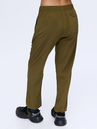 Model standing with back view in Zephyr 26" Pant in Olive, featuring a custom-fit drawstring waist.