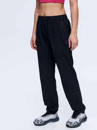 Model standing in Zephyr 29" Pant in Black, featuring a custom-fit drawstring waist.