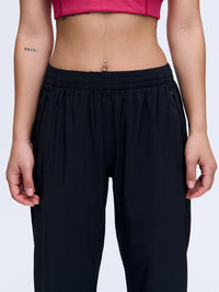 Front view of model wearing Zephyr 29" Pant in Black, featuring an adjustable drawstring waist and zippered pockets.