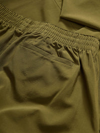 Close-up of Zephyr 29" Pant in Olive, showing elastic waistband and zippered pocket detail.