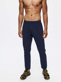 Model standing in Zephyr Pant in Navy, featuring a custom-fit drawstring waist and lightweight design.